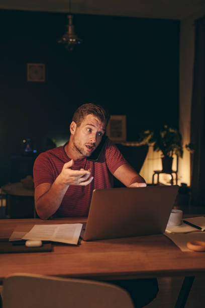istock Handsome Young Businessman Having a Phone Call while Working on a Laptop 1291413572