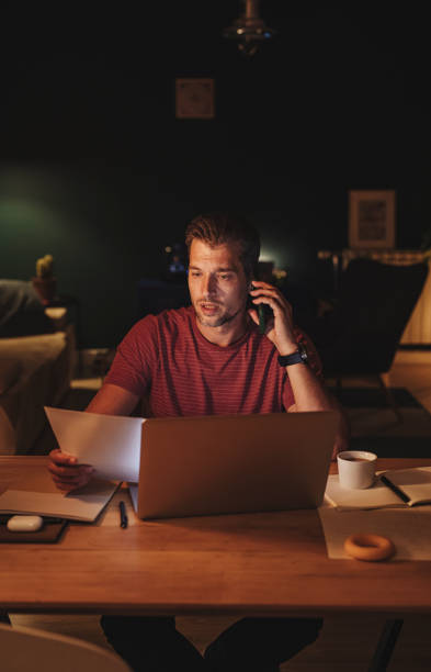 istock Handsome Young Businessman Having a Phone Call while Working on a Laptop 1291413579