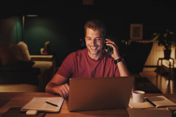 istock Handsome Young Businessman Having a Phone Call while Working on a Laptop 1291413582