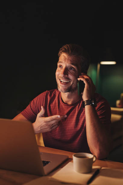 istock Handsome Young Businessman Having a Phone Call while Working on a Laptop 1291413588