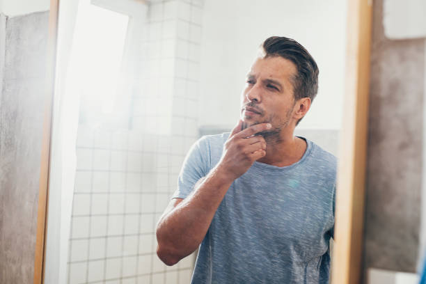 istock Handsome Young Man Checking his Beard in a Bathroom Mirror 1291413623