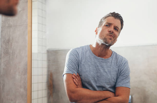 istock Handsome Young Man Checking his Beard in a Bathroom Mirror 1291413630