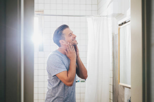 istock Handsome Young Man Checking his Beard in a Bathroom Mirror 1291413631