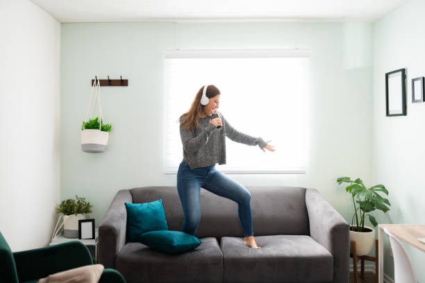 istock Caucasian woman with a cheerful expression dancing on her couch 1291414326