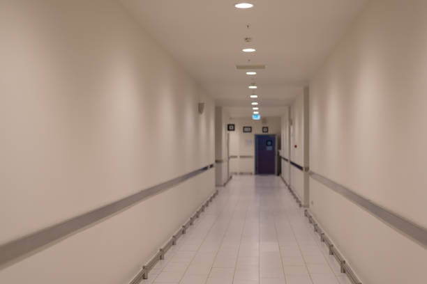 istock Defocused white service corridor without windows in modern building. 1291414984