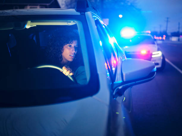 Nightime Police Traffic Stop A young woman, being stopped by police at night for a traffic violation. driving under the influence stock pictures, royalty-free photos & images
