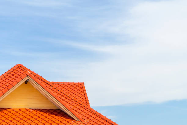 istock Orange tile roof with a blue sky background and clouds and copy space 1291419835