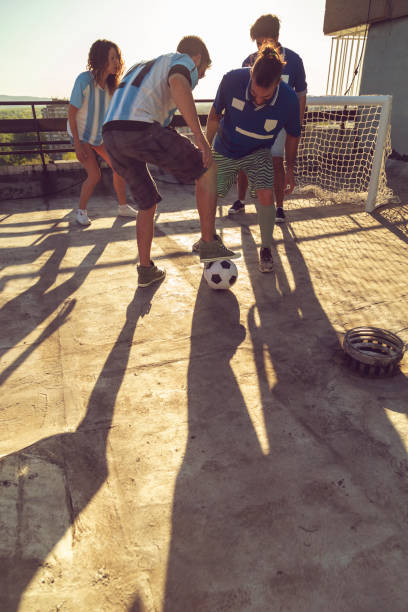 istock Friends playing football on a building rooftop 1291420052