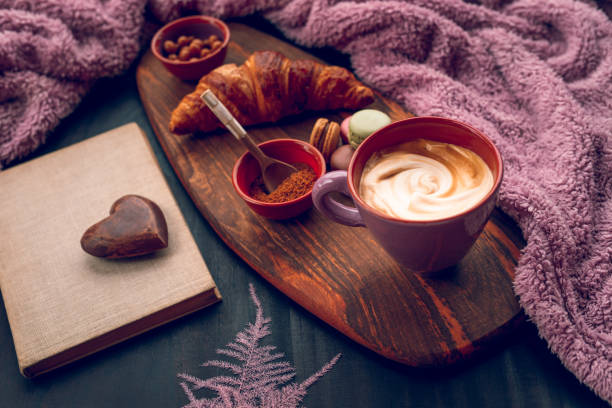 istock Homely boho lilac boho cozy still life with woollen blanket and macaroons, a cup of coffee and an old book 1291421321