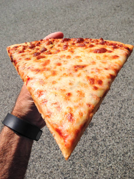 istock man holding a slice of pizza 1291422756