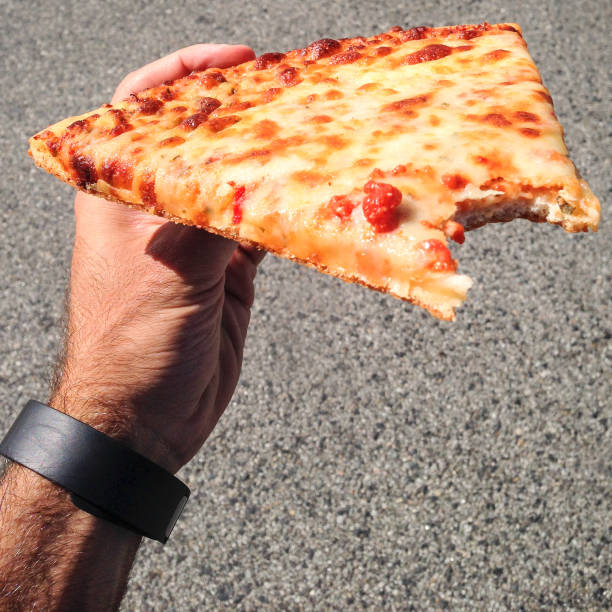 istock man holding a slice of pizza 1291422776