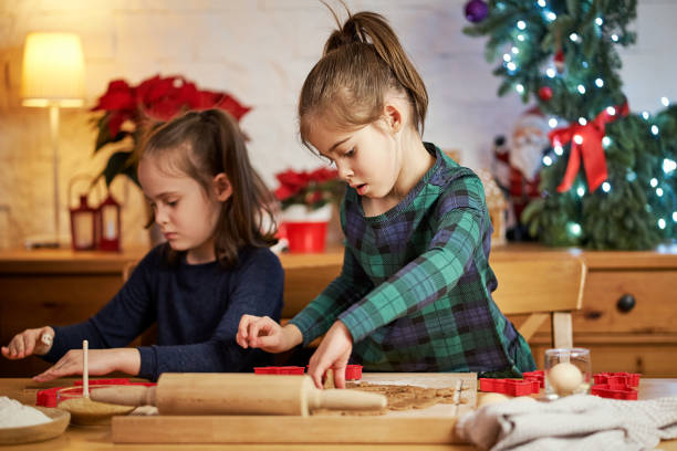 istock two cute sisters make and decorate Christmas gingerbread cookies 1291424206
