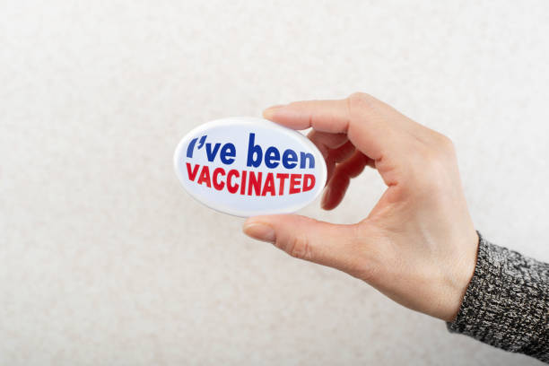 istock Vaccination campaign button pin in caucasian female hand 1291424537