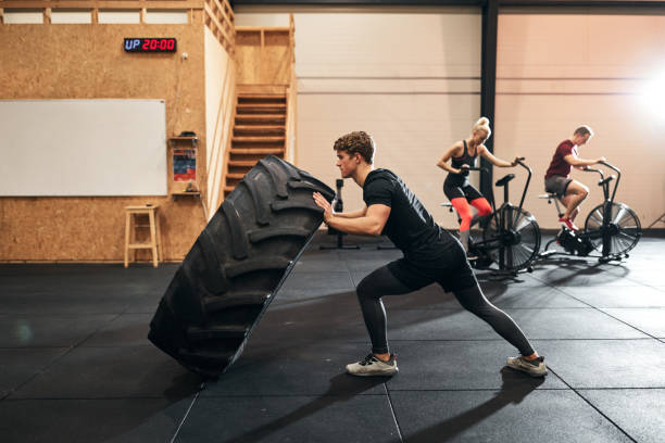 istock Fit young man doing tire flips during a gym workout 1291429919