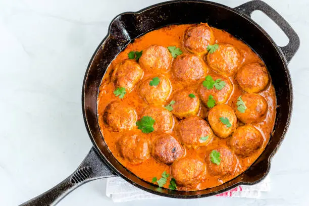 Butter Chicken Meatballs in a Skillet on White Background Flat Lay Top Down Photo, Indian Food Photography