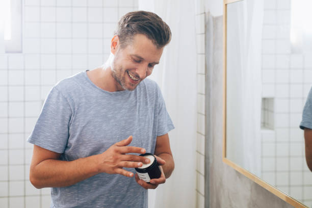 istock Handsome Young Man Using an Aftershave Moisurizer after a Morning Shave 1291430234