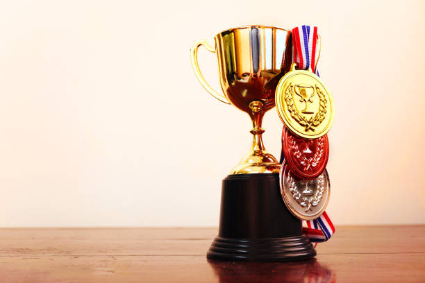 Gold trophy decorate with winner medals lay on the table, win concept.