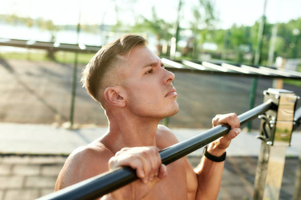 istock Portrait of young caucasian man pulling up on horizontal bar 1291440366