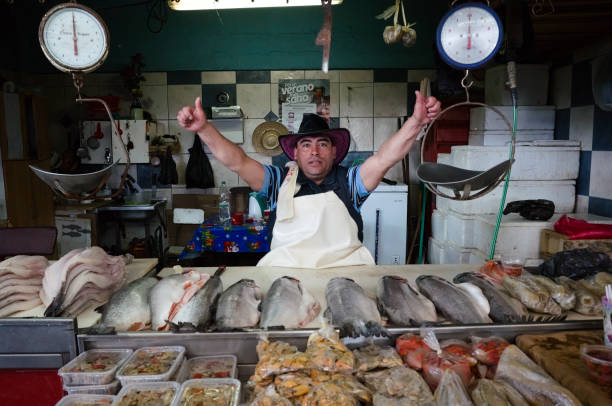 vendedor vende diferentes frutos do mar no mercado local de peixes - human hand hand sign measuring scale - fotografias e filmes do acervo