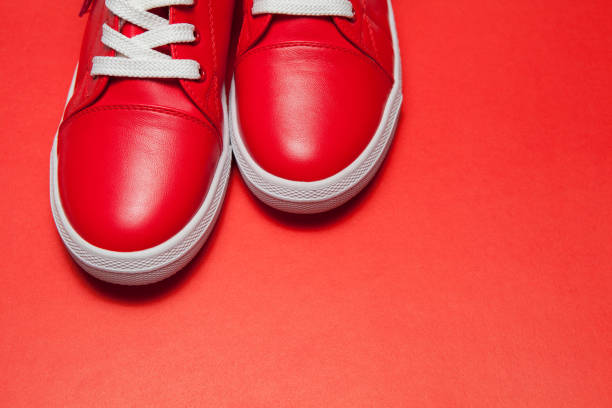 istock Sport red leather sneakers on red background 1291441480