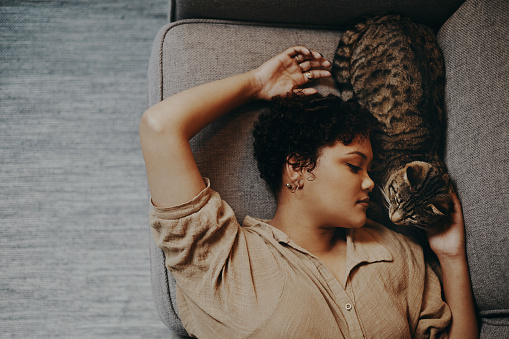 Shot of a young woman relaxing at home with her cat