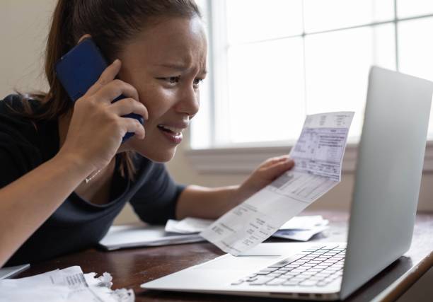 stressed out broke woman checking her bills online. no money. - filipino ethnicity asian ethnicity women computer imagens e fotografias de stock