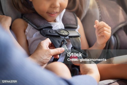 istock Parent buckling her child's seat belt in the car. Transportation safety. 1291443709