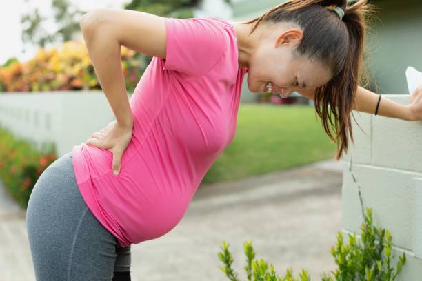 усталая беременная женщина, страдающая от болей в спине. пренатальный стресс. - human spine human age horizontal outdoors стоковые фото и изображения