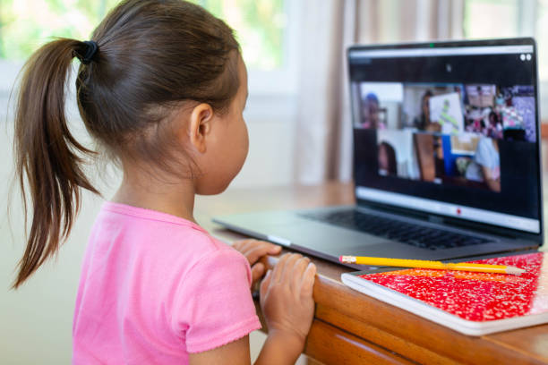 istock A little kid learning online at home school, video class call, book and pencil. 1291446652