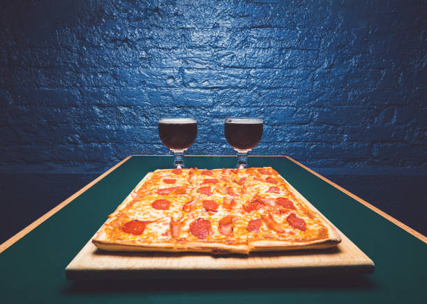 Square pepperoni pizza and two jugs of beer.