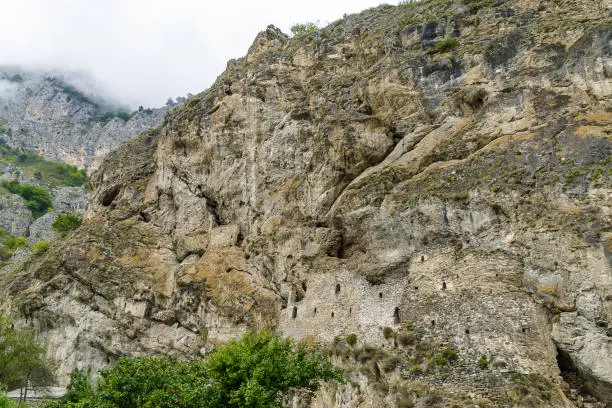 Photo of Cloudy view of medieval rock fortress of Dzivgis village in North Osetia Alania, North Caucasus, Russia