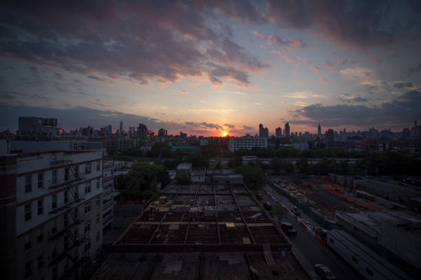 Sunset over Williamsburg, Brooklyn The sun sets behind the Manhattan skyline. Seen from a rooftop in Brooklyn. williamsburg bridge stock pictures, royalty-free photos & images