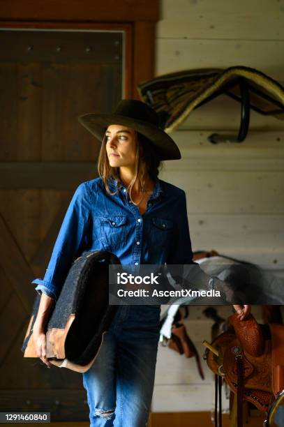 Female Rancher In A Tacking Room Stock Photo - Download Image Now - Cowgirl, 30-39 Years, Adult