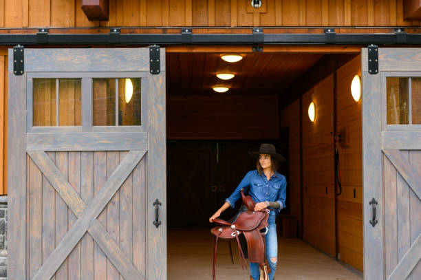 Female rancher in a tacking room Female farmer in a tacking room. Rancher working on a Canadian ranch. Empowered woman working in agriculture. pemberton bc stock pictures, royalty-free photos & images