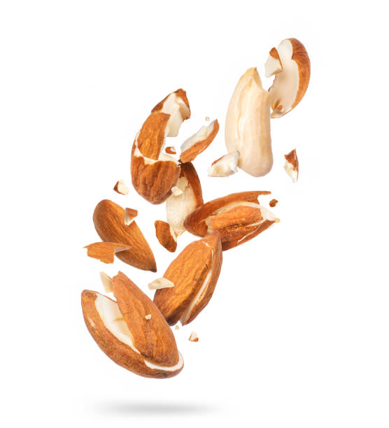 istock Crushed almonds in the air into many pieces isolated on white background 1291465980
