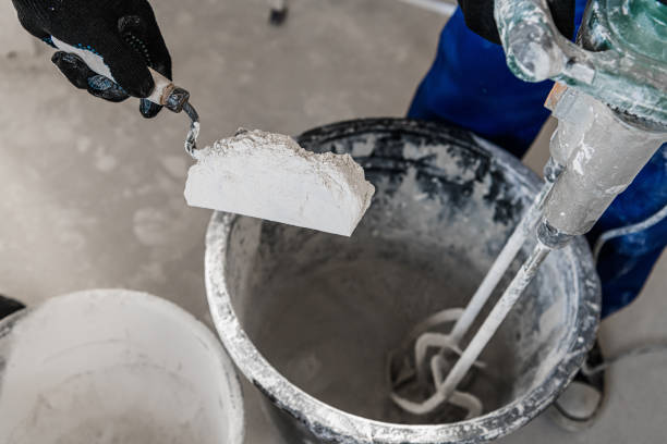 istock Workman put dry cement into a bucket with a spatula 1291467075