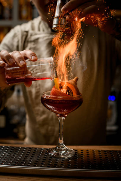 barman añadir ingredientes al vaso con calabaza y pimienta en el interior y hace fuego sobre él - smooth part of colors yellow fotografías e imágenes de stock