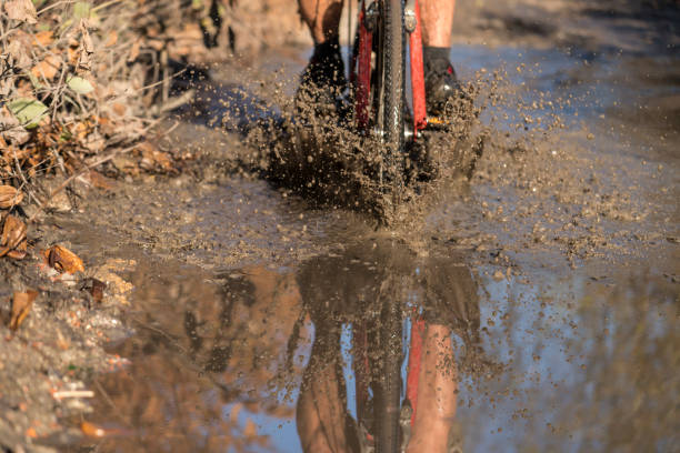 istock Driving a bike in muddy dirt road 1291473409
