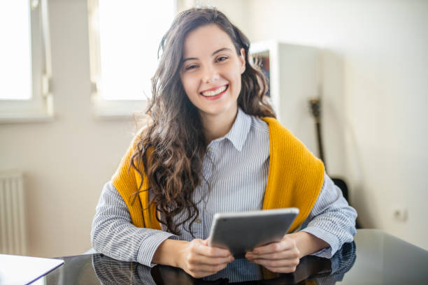 istock Beautiful young woman using digital tablet and working at home office 1291473477