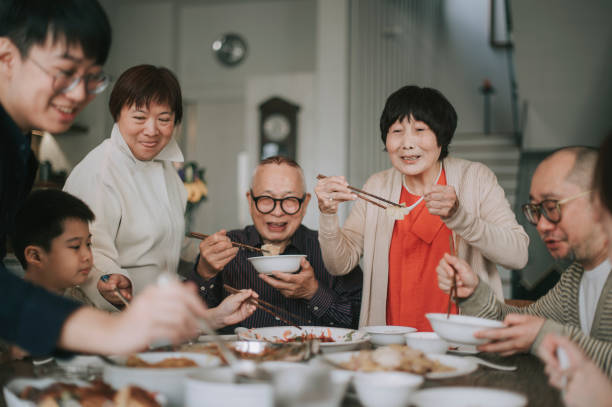 asiatische chinesische familie chinesische sendejahr wiedersehen abendessen mit traditionellen gerichten am esstisch - essen mund benutzen fotos stock-fotos und bilder