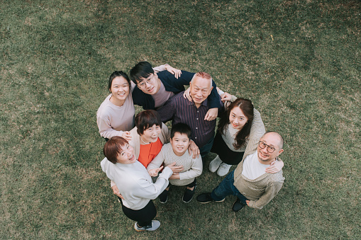 directly above asian chinese multi generation family looking up at camera smiling outdoor portrait