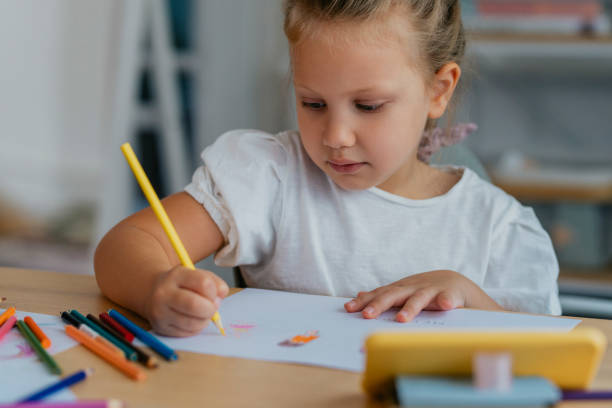 istock A Cute Girl Looking at her Smartphone and Drawing 1291476376