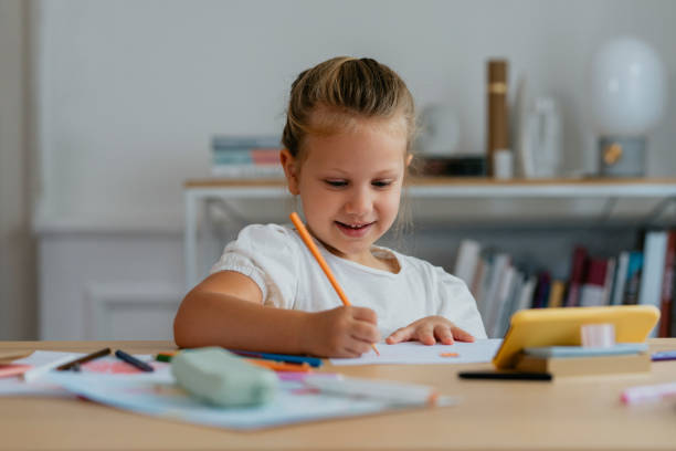 istock A Cute Girl Looking at her Smartphone and Drawing 1291476378