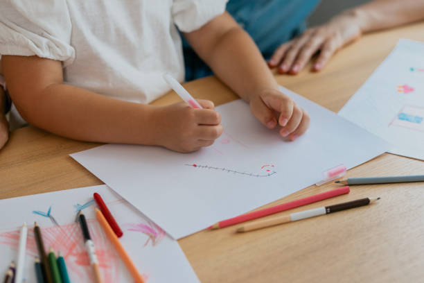 istock Anonymous Little Girl Drawing with her Mom's Assistance 1291476418