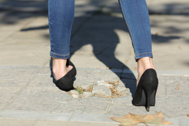 donna che cammina distorsione caviglia inciampando in strada - twisted ankle immagine foto e immagini stock
