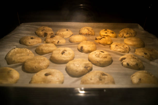Chocolate chip cookies lined on a tray in the oven