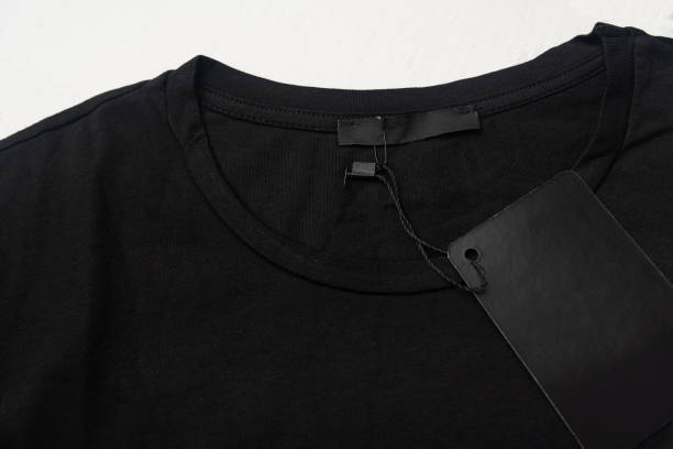 istock Blank label and tag on a black cotton T-shirt. Close-up. 1291483406