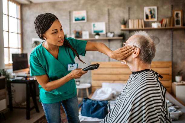 istock Visiting nurse giving a haircut at home 1291484045