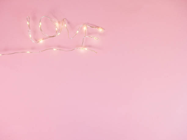 istock Electric lights put in love text on pink background 1291485497