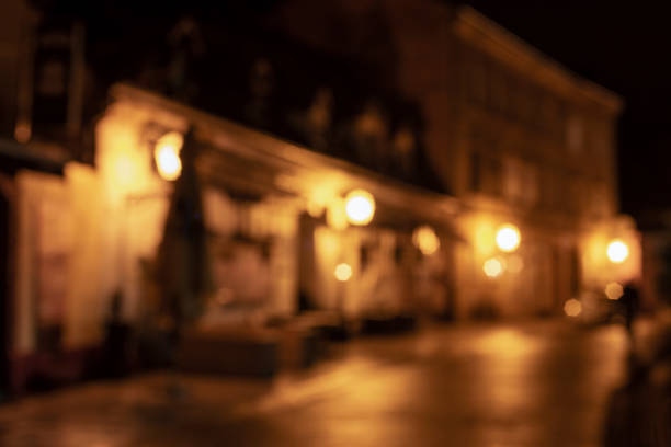 istock Blurred background of illuminated street at night 1291488979